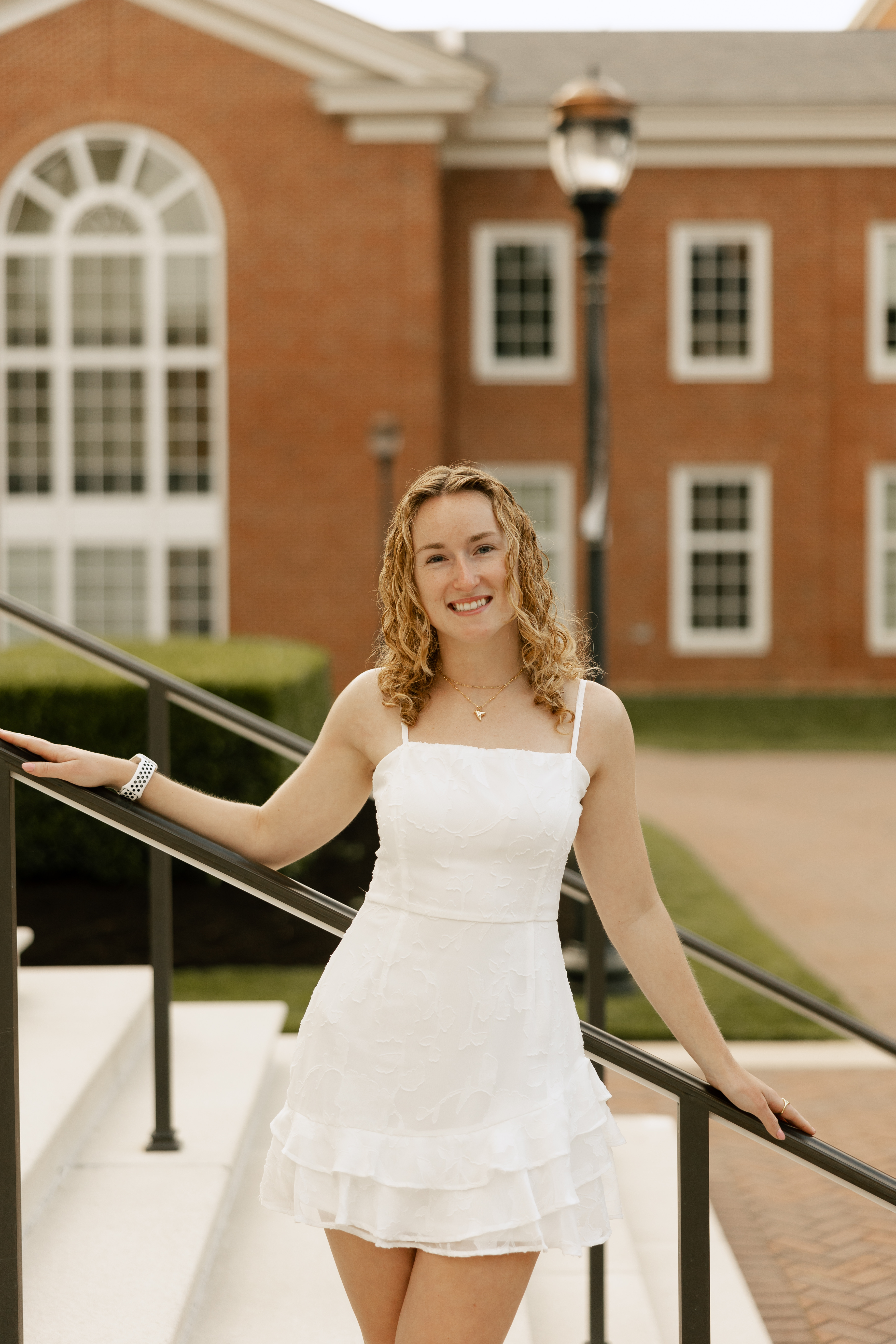 Summer, a white woman with blonde hair, stands on a stairwell.